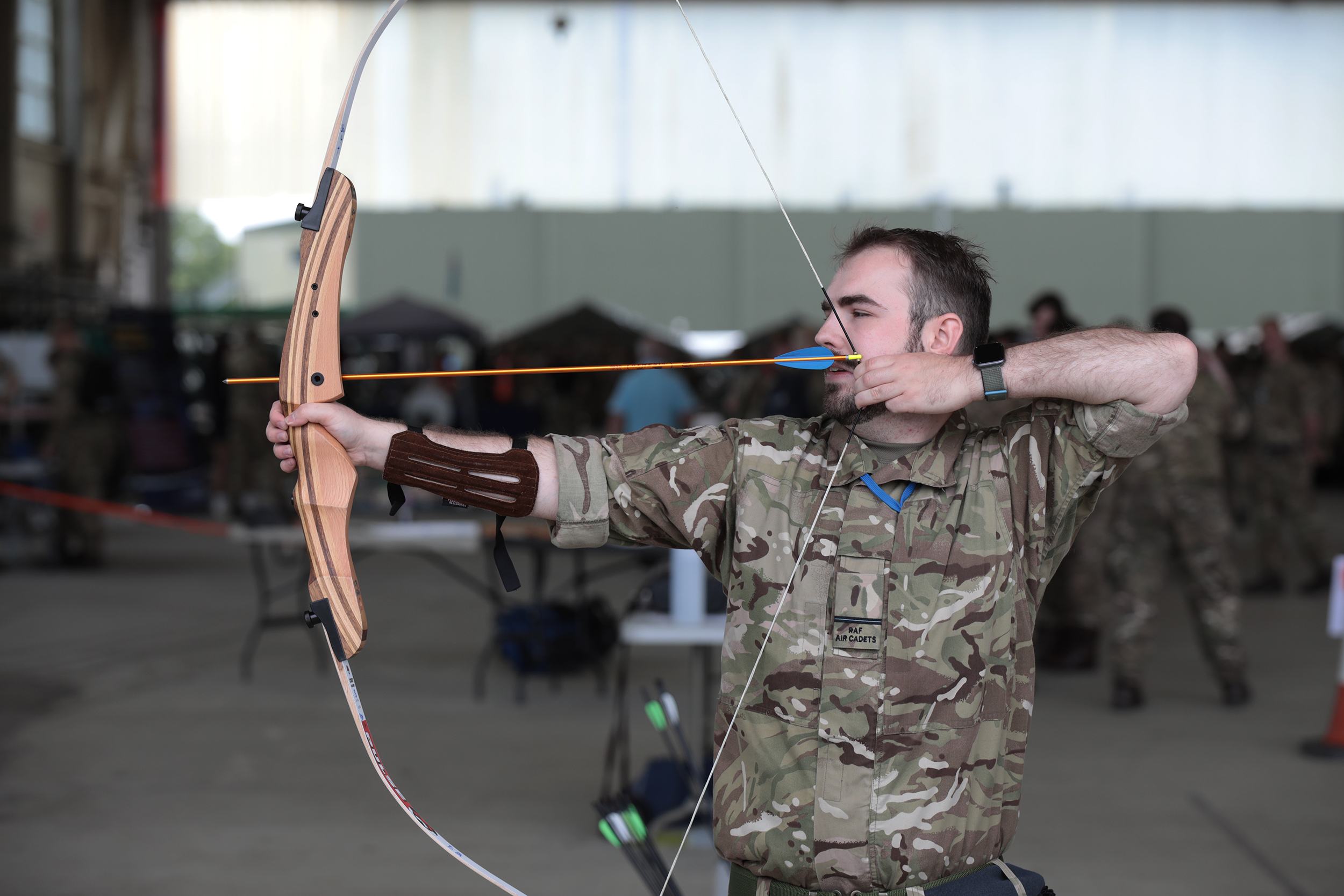 CFAV poses during archery with bow and arrow in a firing stance