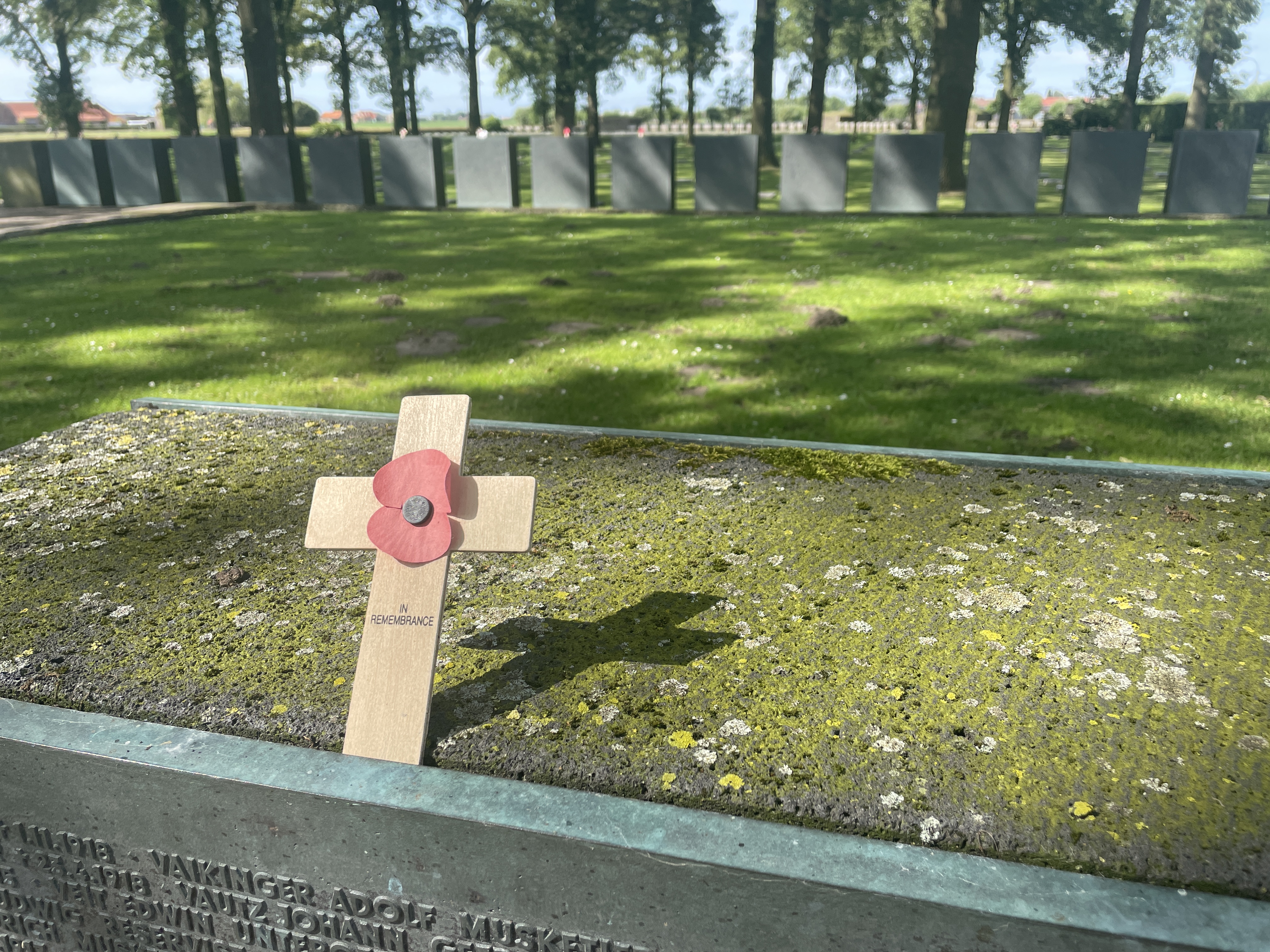 World War 1 memorial with a wooden cross and poppy laid atop