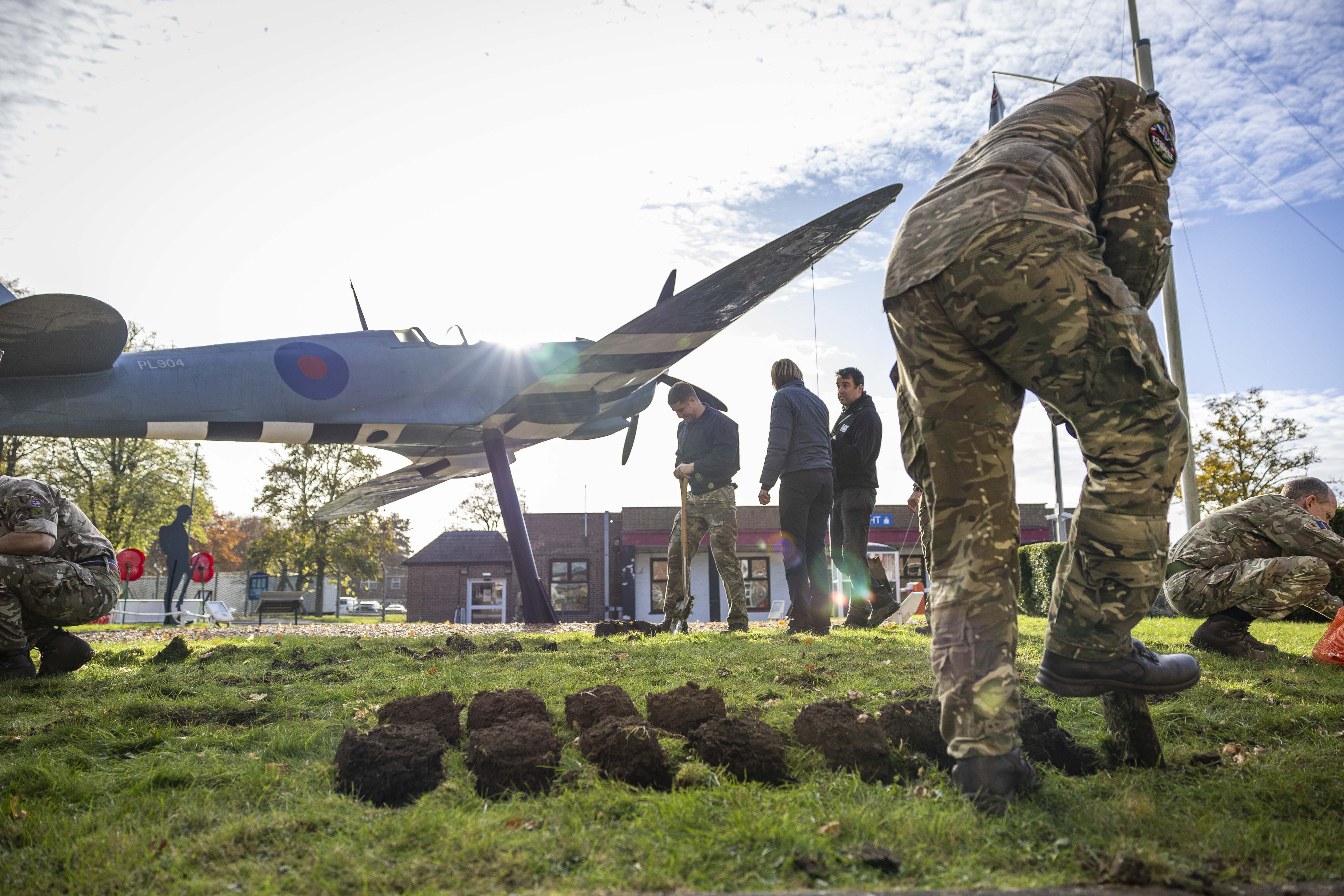 Personnel use shovels to dig the ground. 