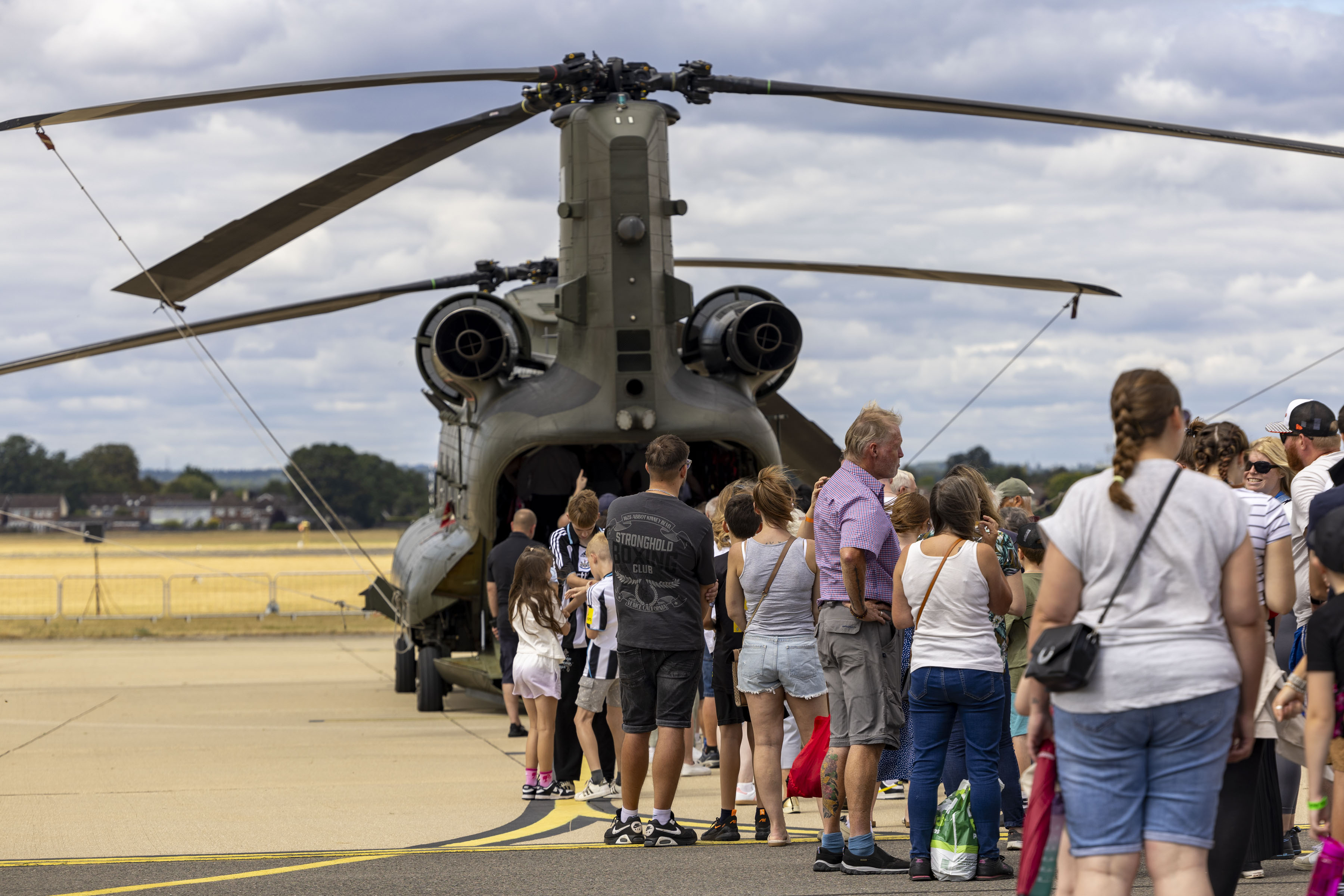 Families waiting to board a Chinook helicopter to walk through and meet the crew from 28 (AC) Squadron. 