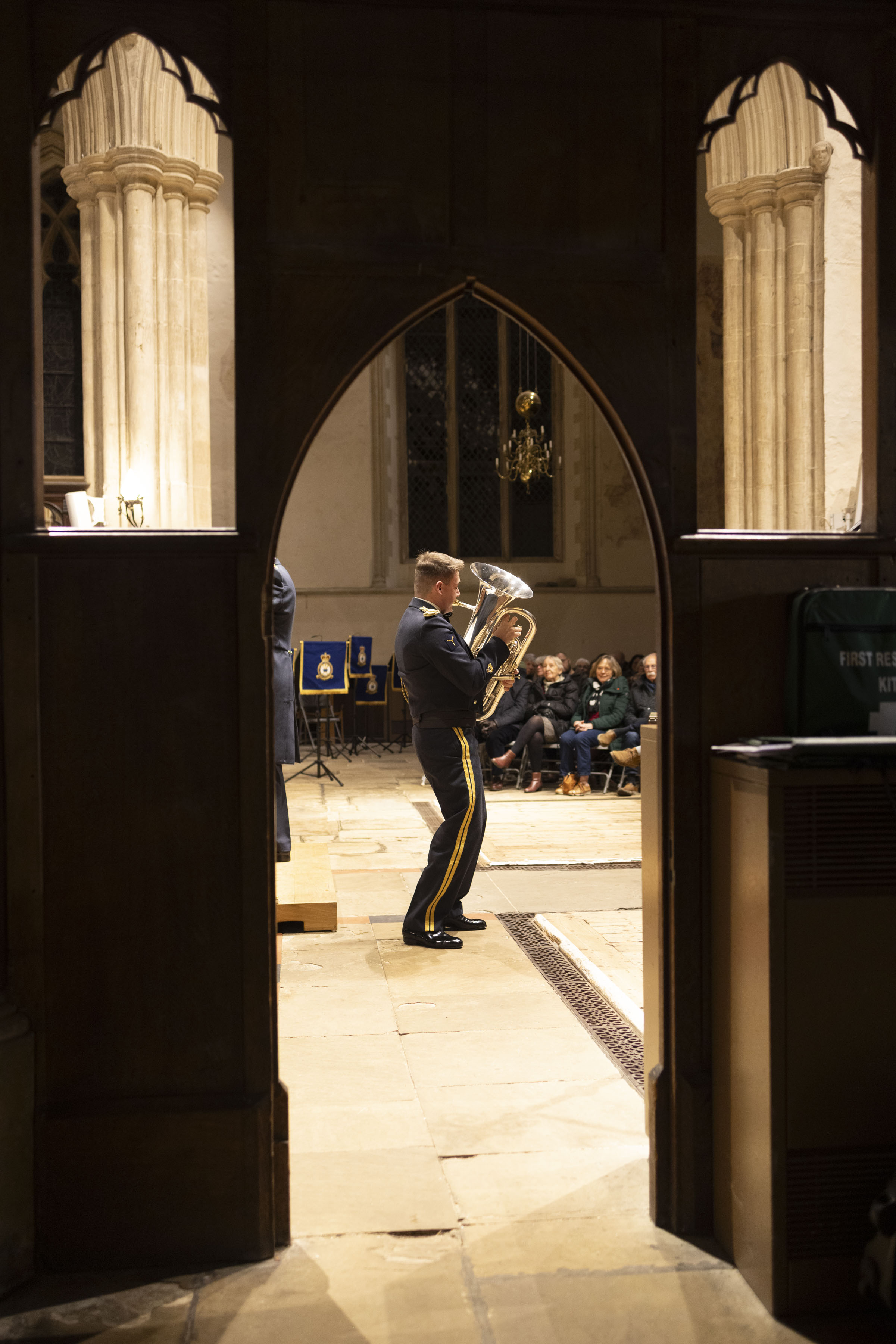 AS1 Dickens performing his solo. Image taken through a wooden archway, focusing on the musician playing.