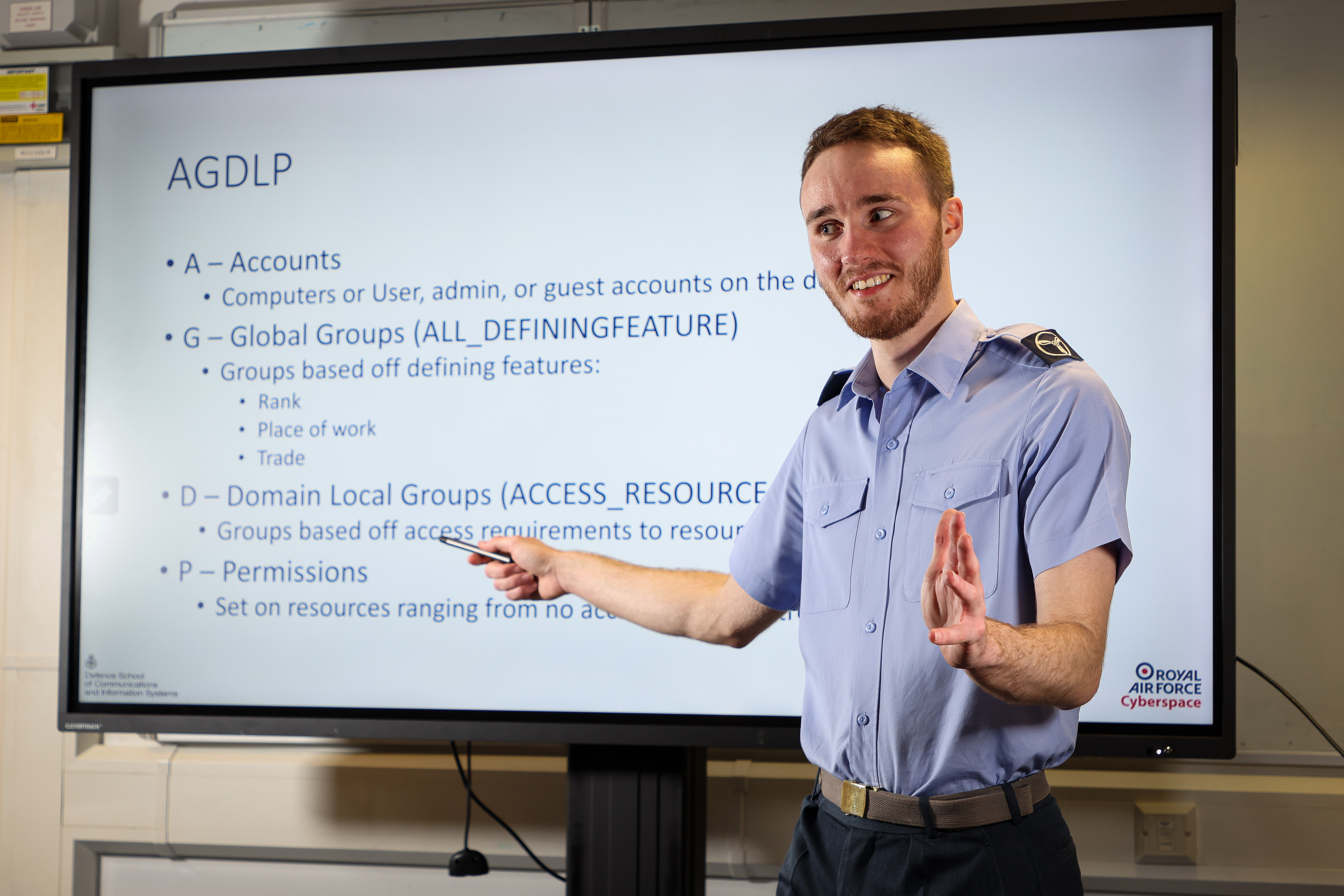 AS1(T) Dominic Maxwell in front of a teaching board within a No.1 Radio School classroom. 