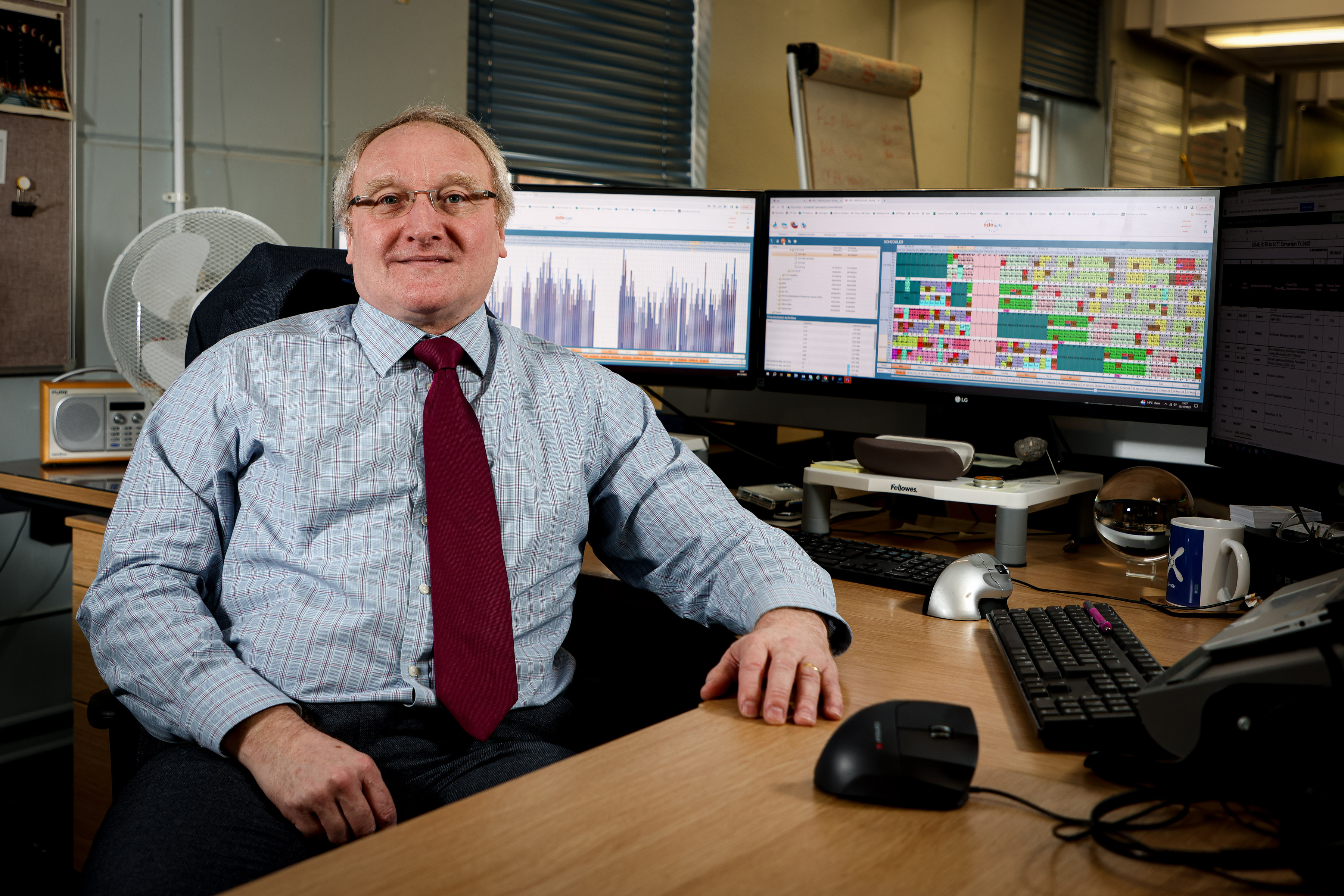 Kev O'Halloran sat at his desk in front of his computer showing the work that he does. 