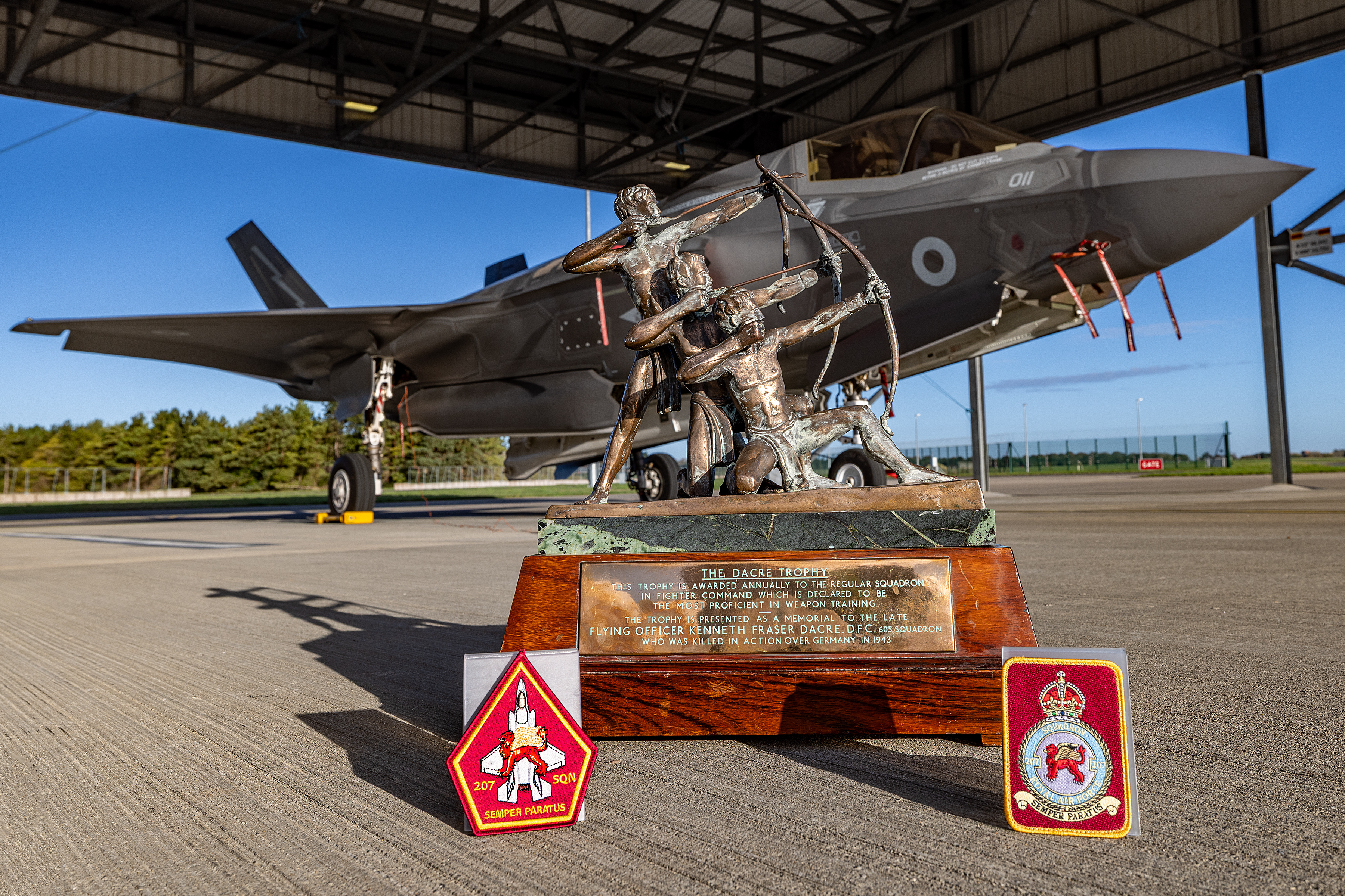 Dacre Trophy with 207 Squadron patches presented in front of an F35-B aircraft