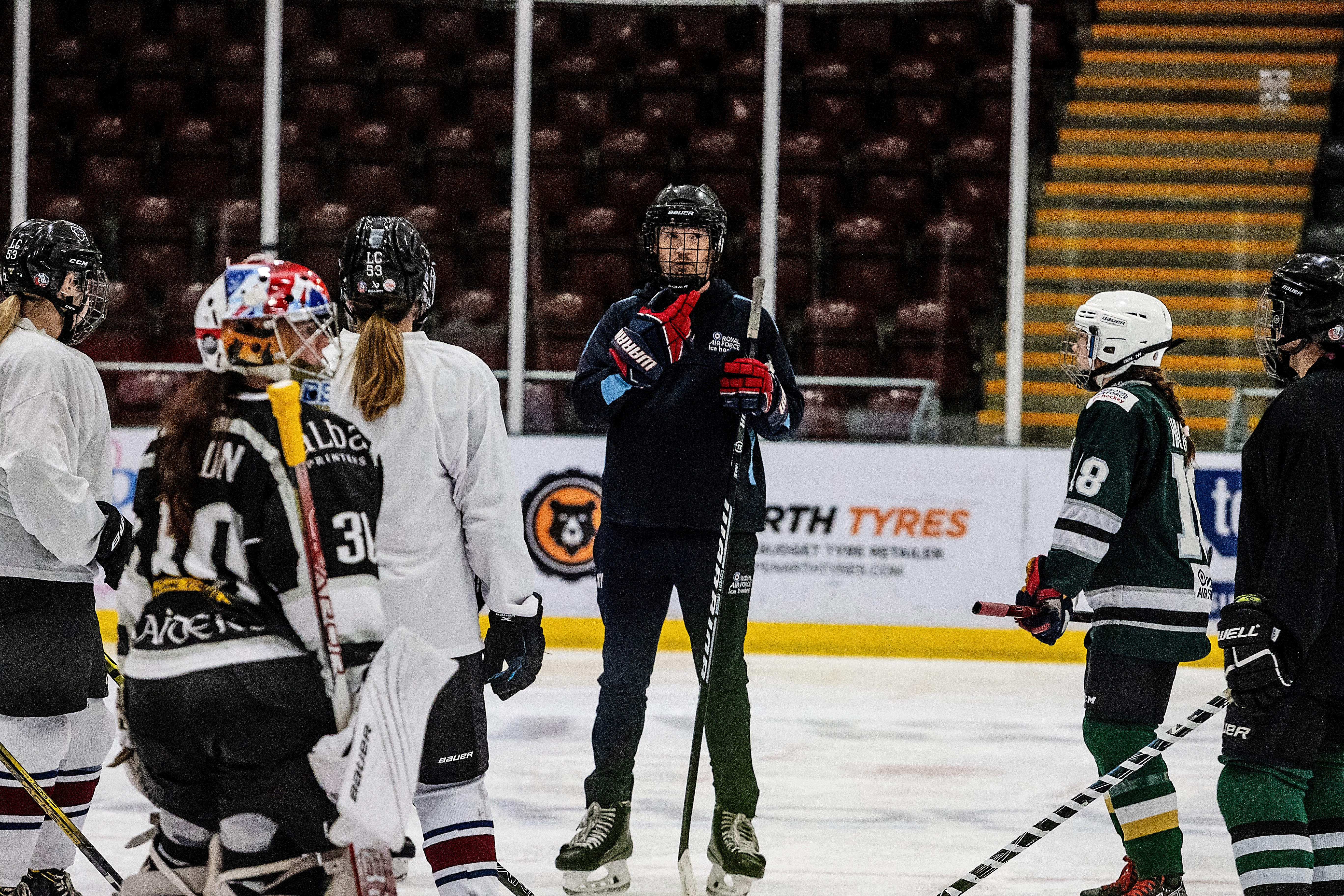 Corporal Young coaching the team on the ice - Photo credit: Trish Thompson Photography