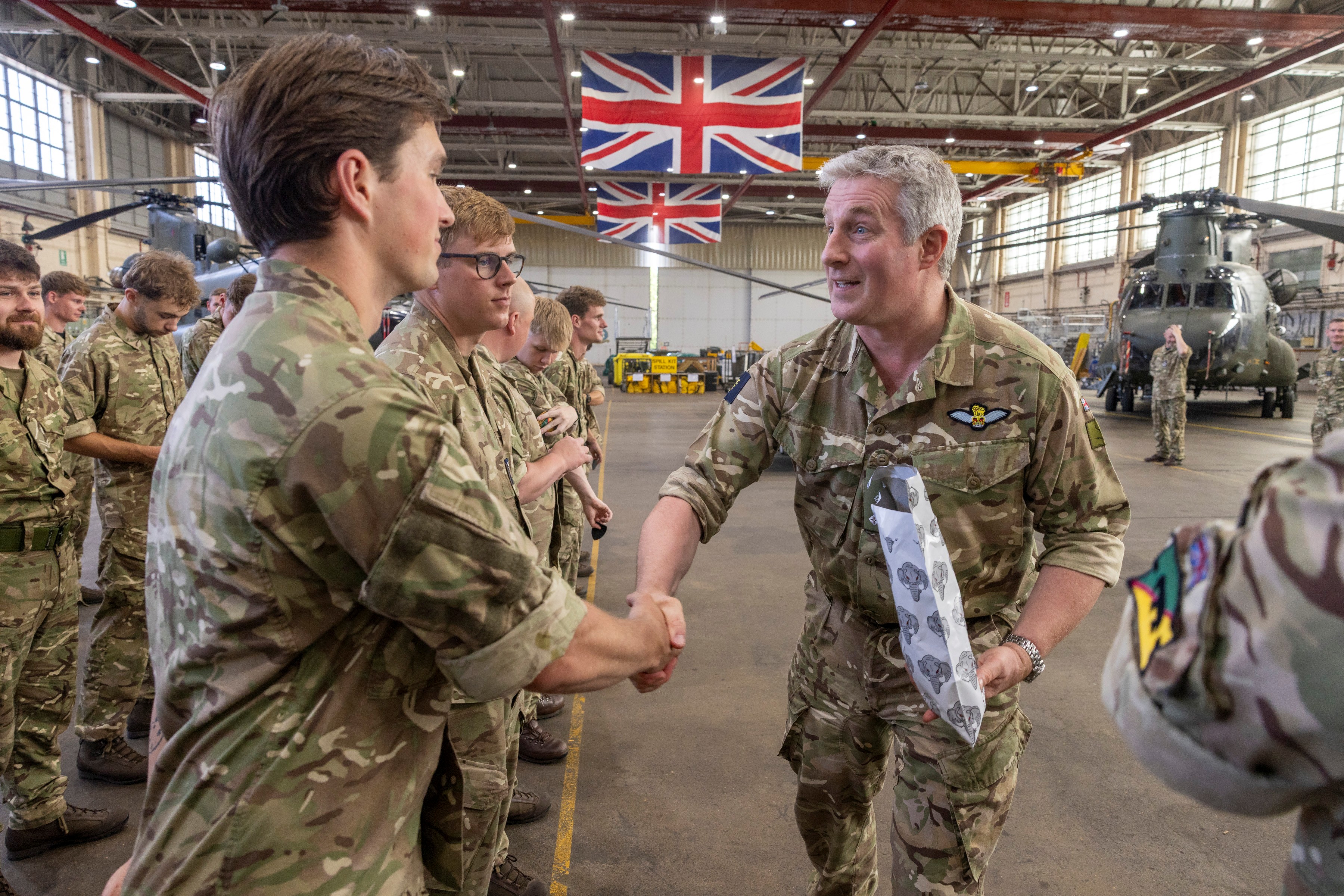 The Chief of Staff of Joint Aviation Command congratulates 27 Squadron personnel with a handshake