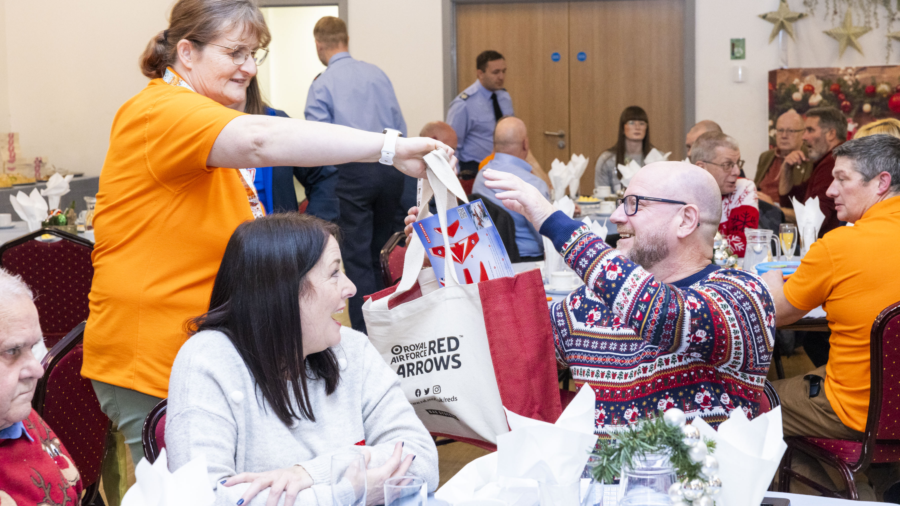 A member of the Waddington Community Support team hands a gift bag out to a lucky guest.
