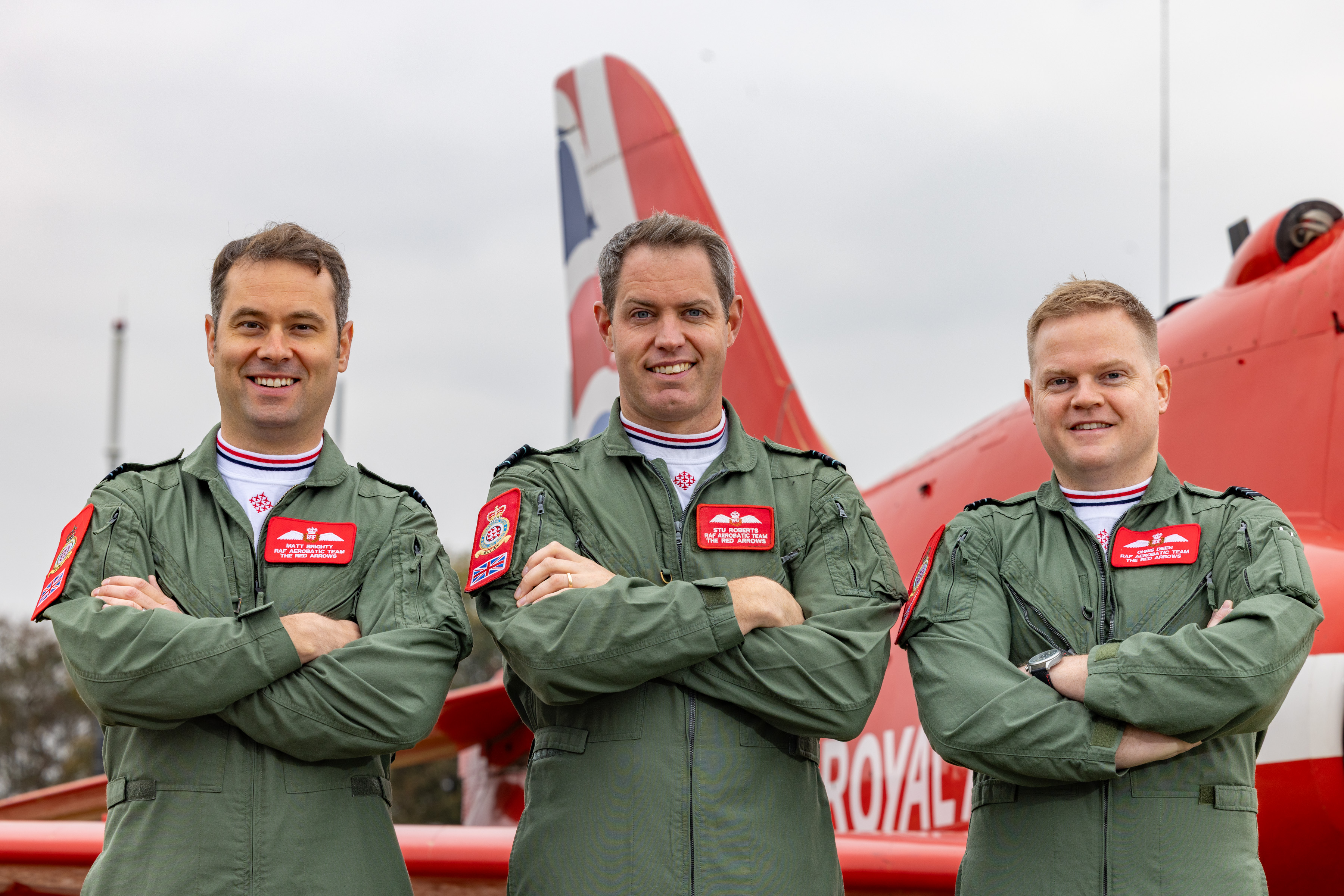 The three new pilots joining the Red Arrows for 2026 stand in front of a Hawk jet. They include (left-to-right) Flight Lieutenant Matt Brighty, Squadron Leader Stu Roberts and Flight Lieutenant Christopher Deen.