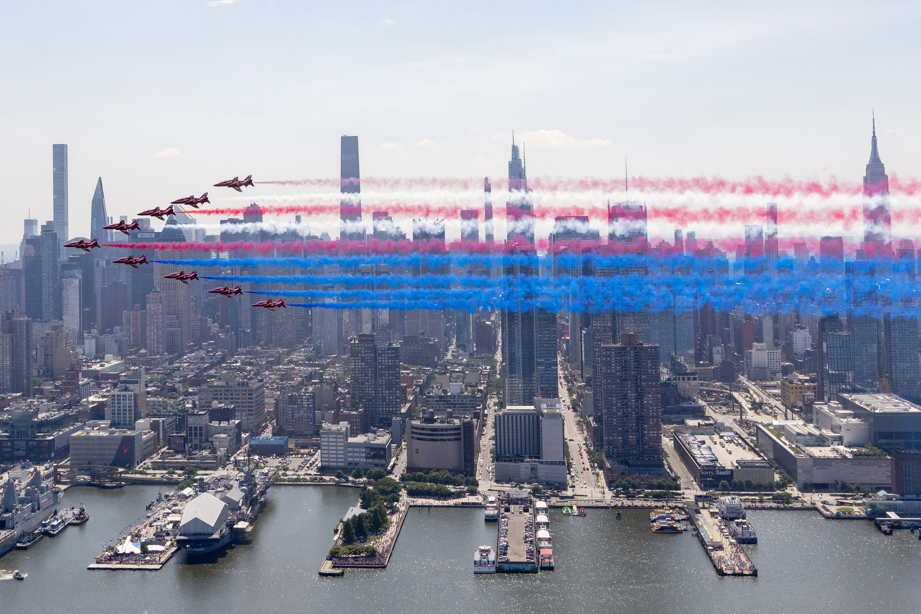 The Red Arrows seen flying over New York on July 4 - trailing red, white and blue smoke colours.