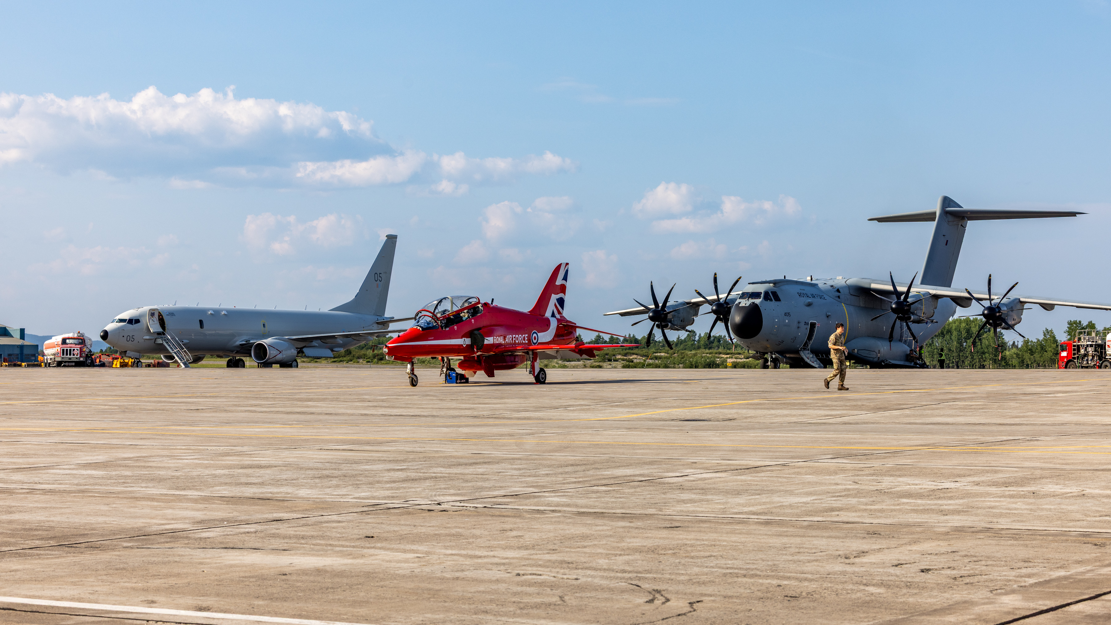 RAF P-8 and A400M Atlas aircraft are parked in the background at Goose Bay, with a Red Arrows Hawk in front of them.