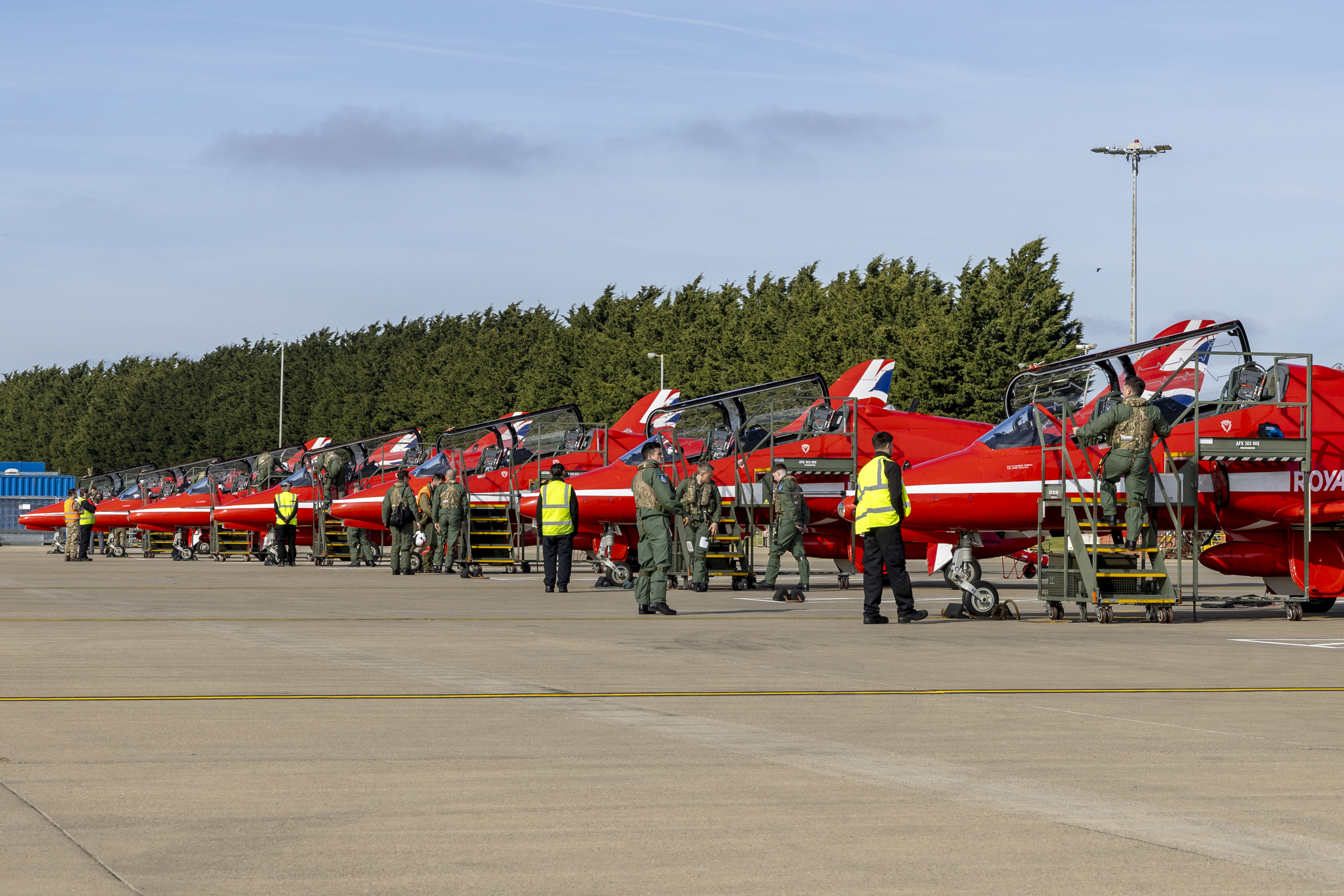 Red Arrows jets in a line on the ground in front of a hangar at RAF Waddington.