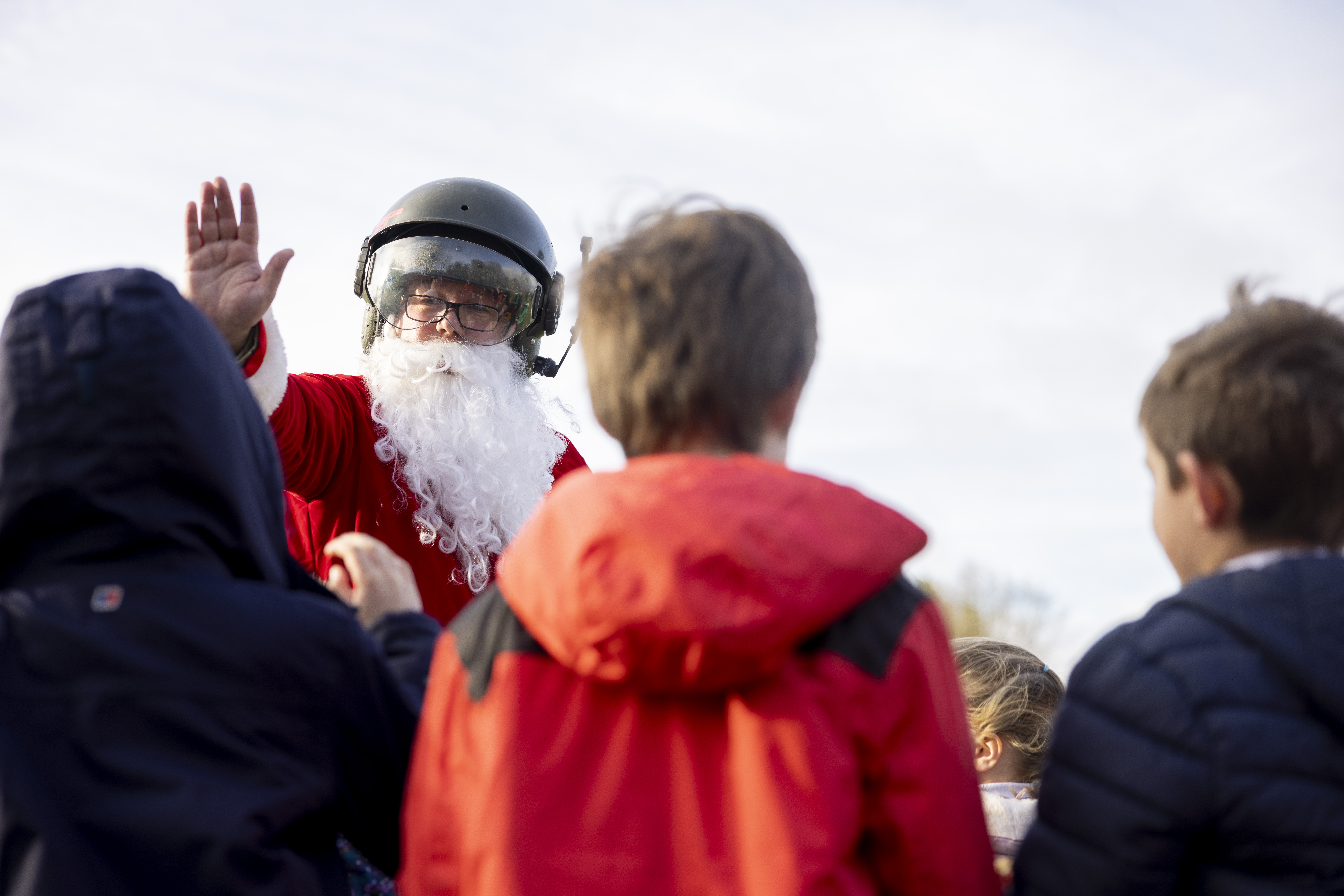 Santa waves to school children. 