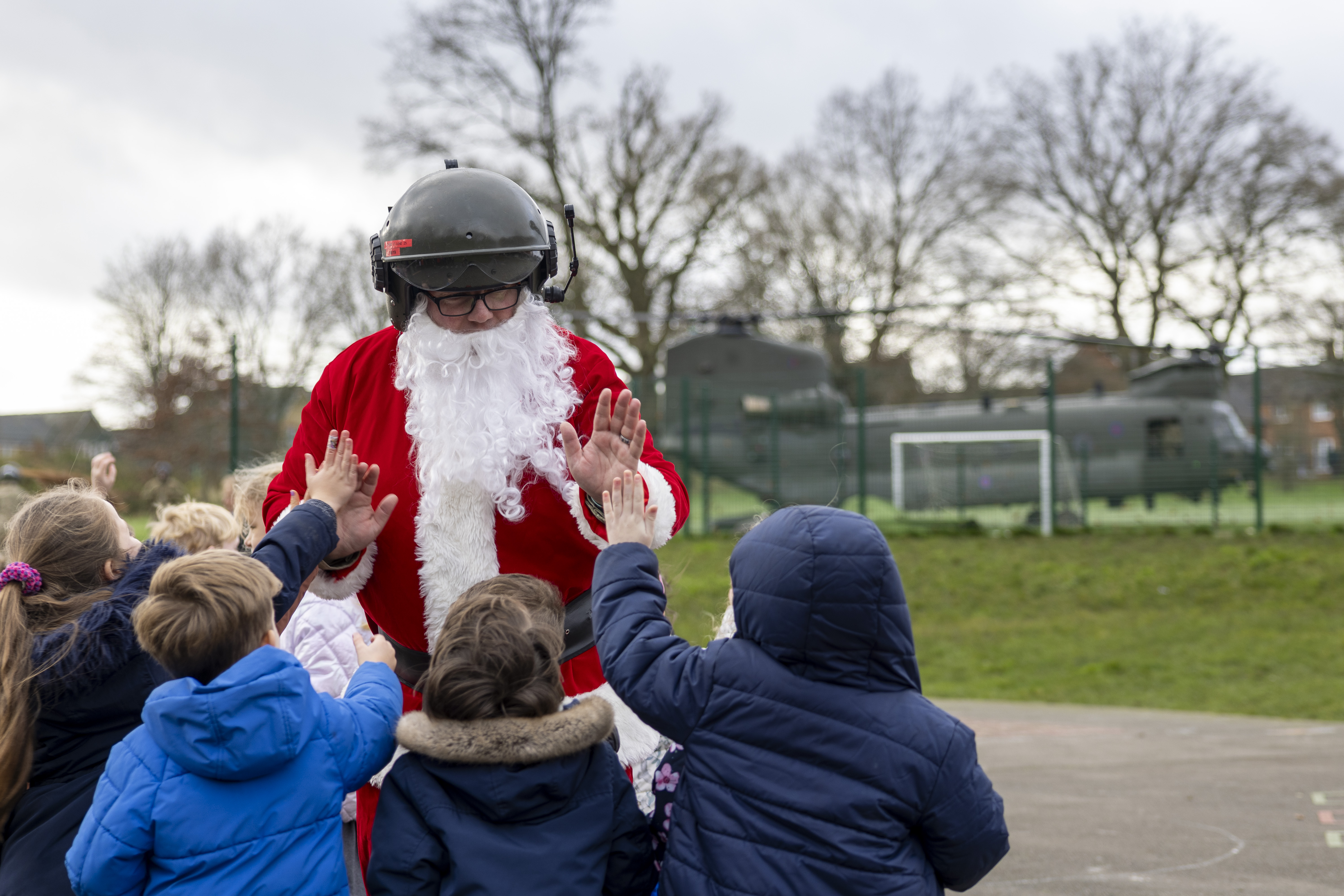 Santa high fives school children.