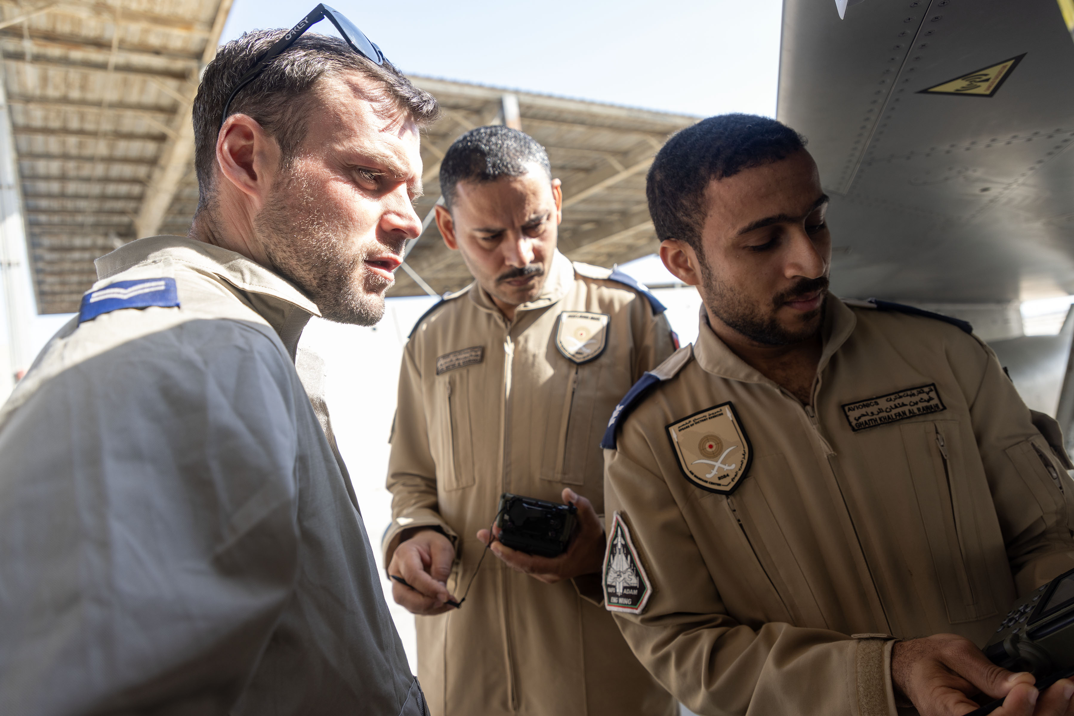 Three servicepeople looking at something together