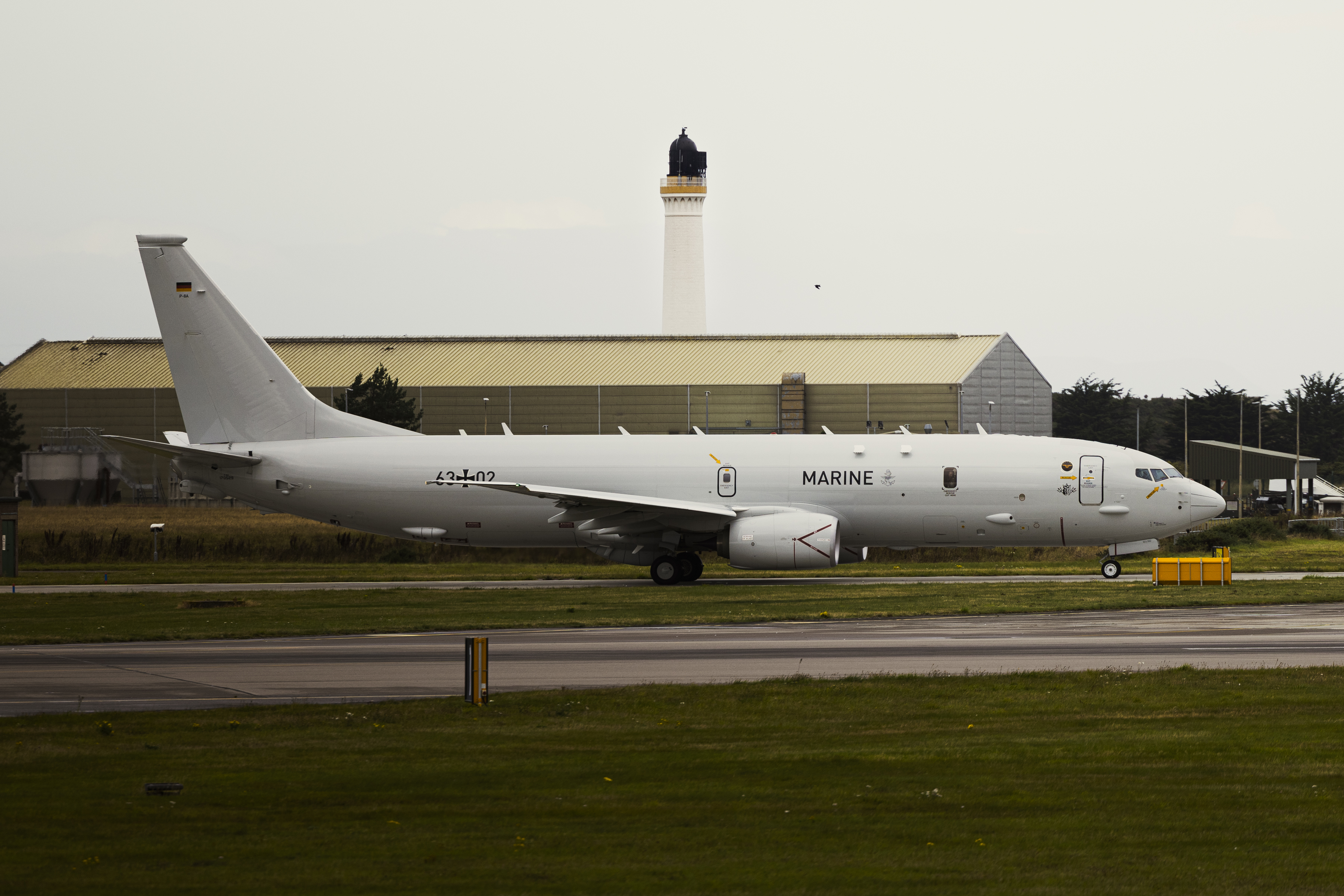 A German air force P-8 Poseidon taxing out with the Lossiemouth lighthouse in the background.