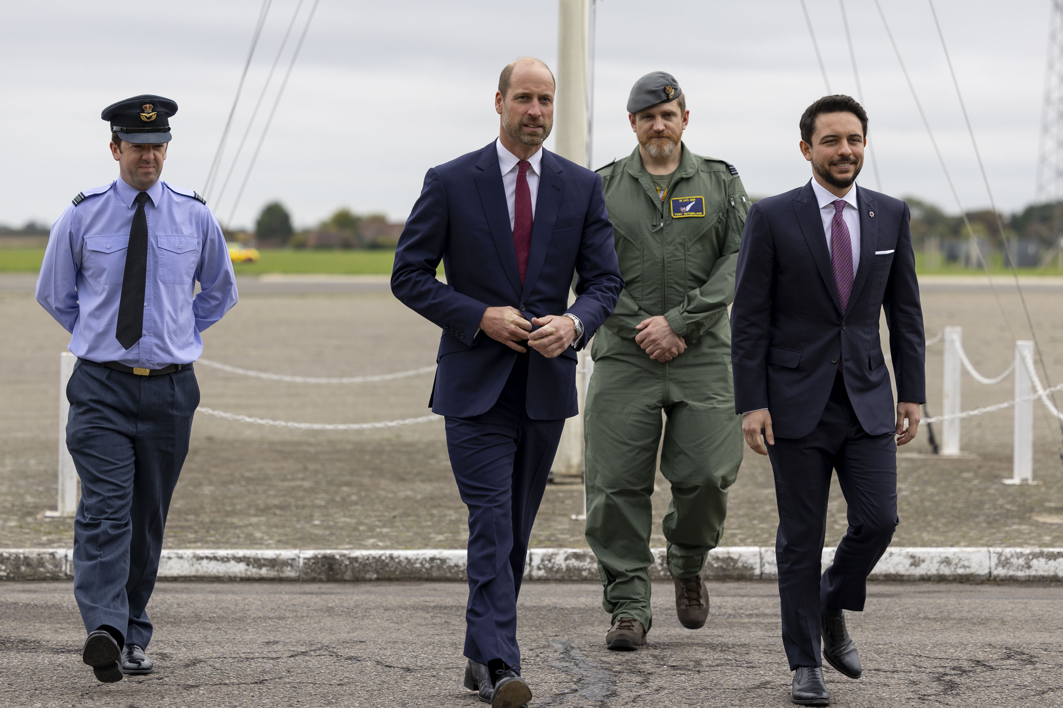 The two Princes walk side by side with aircrew at RAF Benson.